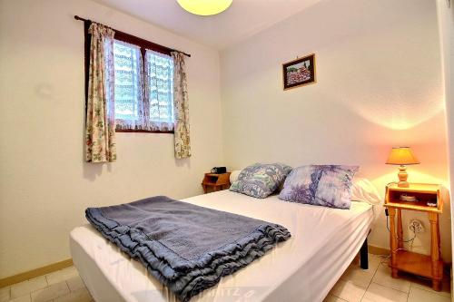 Schlafzimmer mit einem Bett und einem Fenster in der Unterkunft Pavillon indépendant pour 6 personnes dans une résidence sécurisée avec piscine in Valras-Plage