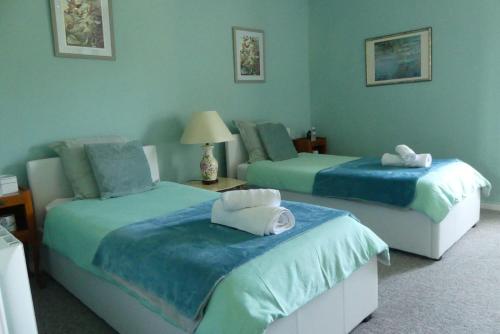 deux lits dans une chambre aux murs bleus dans l'établissement Maison Du Cheval, à Chalais
