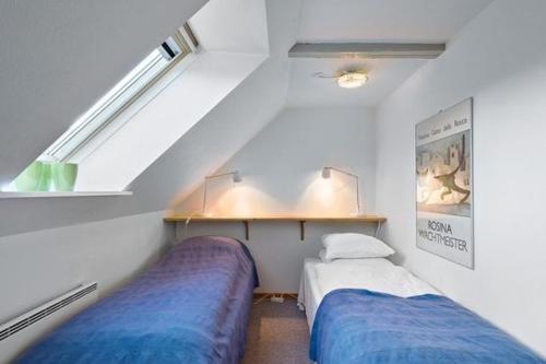 a room with two beds and a sloped ceiling at Strandsegård Ferielejlighed in Ølsted