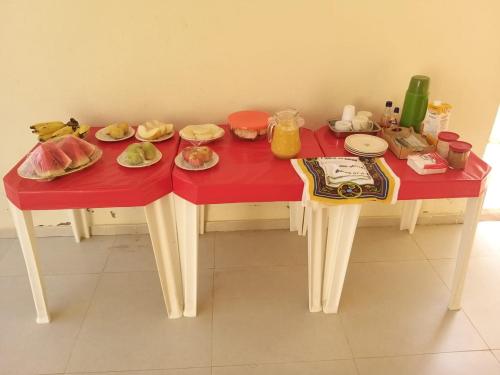 una mesa roja con platos de comida. en Propriedade patolo, en São Miguel dos Milagres