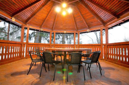 a table and chairs in a wooden pavilion with a ceiling at Privilegio 148 Sâmbăta in Sîmbăta de Sus