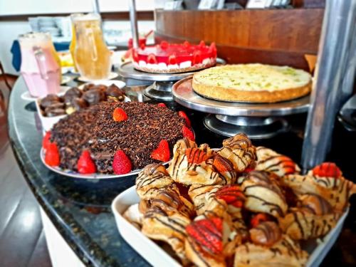a table topped with lots of different types of pastries at Wynn Batel in Curitiba
