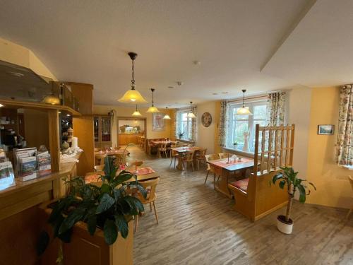 a restaurant with tables and chairs in a room at Landgasthaus Zander in Blankenburg