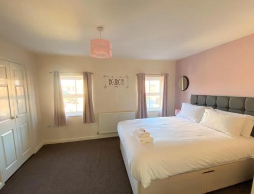 a bedroom with a large white bed with two towels on it at Johnson Townhouse in Wellingborough