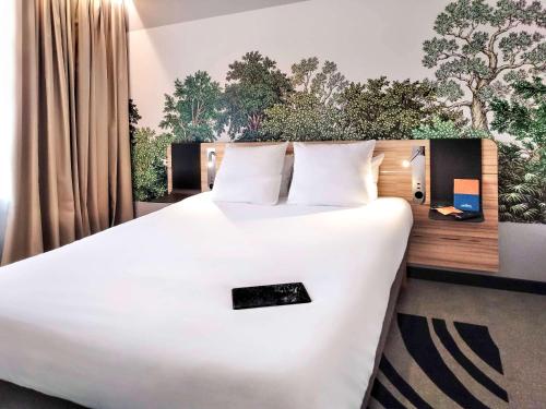 モンペリエにあるNovotel Suites Montpellier Antigoneの窓付きの客室で、白い大型ベッド1台が備わります。