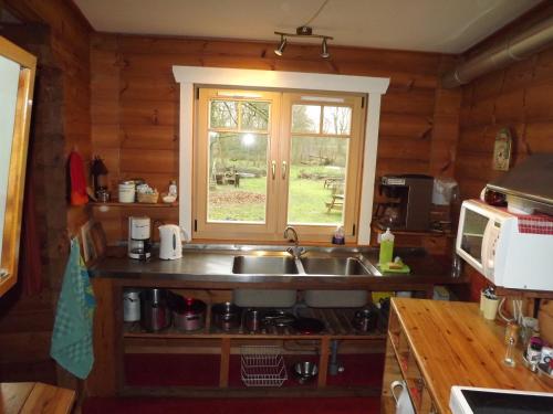 una cucina con lavandino e finestra di Pension Groenewoud appartementen vrijdag tot maandag en maandag tot vrijdag a Swalmen