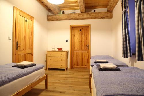 1 dormitorio con 2 camas y suelo de madera en Wellness chalupa Šindelka en Králíky