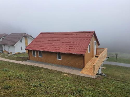 a small house with a red roof and a ramp at Three Stars Luxury House ART-PE with pool and SPA pool in Trebnje