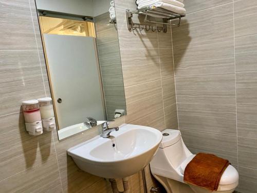 a bathroom with a sink and a toilet and a mirror at SH Hotel Kota Damansara in Kota Damansara