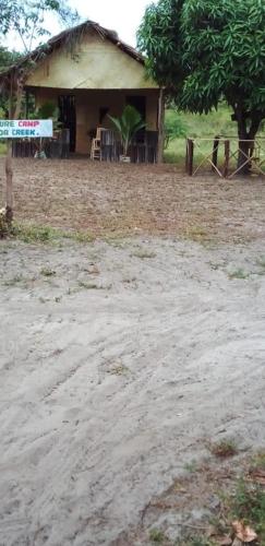 a house with a dirt road in front of it at Mida Creek Nature Camp in Watamu