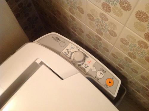 a white toilet in a bathroom with a control panel at Yamaichi Bekkan in Miyajima