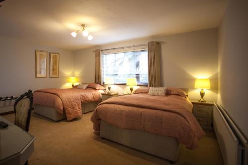 a bedroom with two beds and a window at Keef Halla Country House in Crumlin