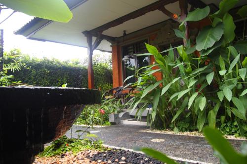 a porch of a house with a bunch of plants at Yulia Village Inn Ubud in Ubud