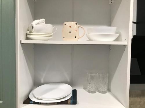 a white cabinet with plates and dishes on it at Arcadia sky in Odesa