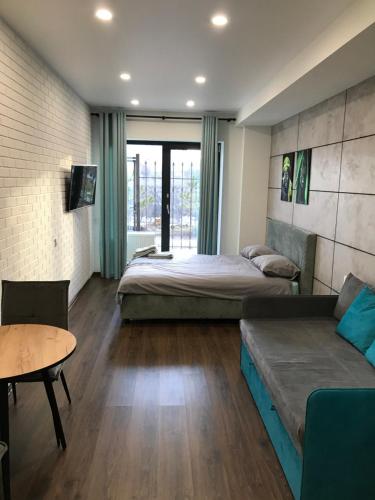 a bedroom with a bed and a table and a couch at Arcadia sky in Odesa
