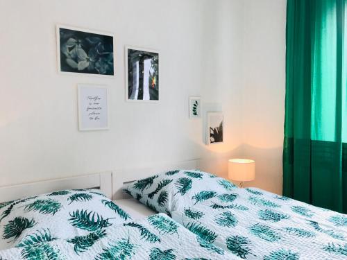 a bedroom with a bed with a green and white comforter at Eifel-House - FeWo in Weilerswist