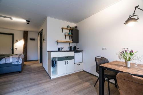 a living room with a table and a dining room at B&B De Oldambtster in Beerta