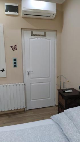 a white door in a bedroom with a bed and a desk at Erika Vendégház in Mogyoród