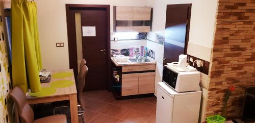 a small kitchen with a sink and a refrigerator at Erika Vendégház in Mogyoród