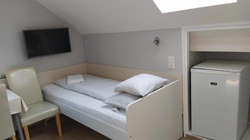 莫格羅的住宿－埃里卡旅館，小房间设有床铺和电视