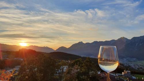 a glass of wine sitting on top of a mountain at Gschwendtalm Tirol - Luxus-Apartment für Ihre Auszeit in Tulfes