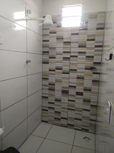 La salle de bains est pourvue d'une douche avec une porte en verre. dans l'établissement Hotel Lucena, à Guarabira
