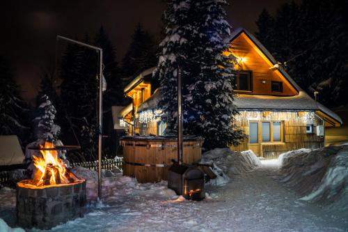 a fire pit in front of a house in the snow at Sielankowo-dom na wyłączność in Istebna
