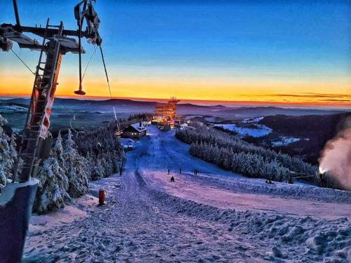 a ski lift with people on a snow covered slope at Wellness chalupa Šindelka in Králíky