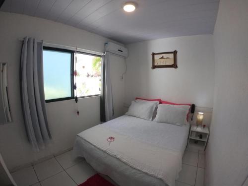 een kleine slaapkamer met een bed en een raam bij Pousada America do Sol in Natal