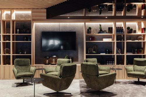 a waiting room with chairs and a flat screen tv at Alpenstern Genießerhotel in Damuls