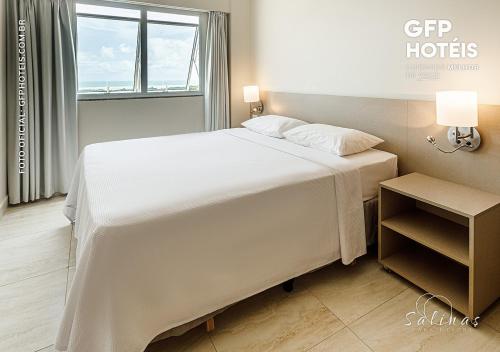 a white bed in a room with a window at SALINAS PARK - GAV Resorts in Salinópolis