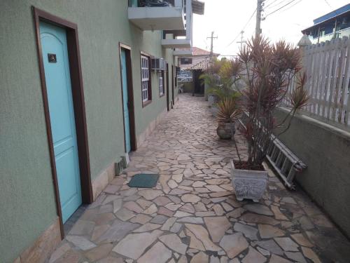 a stone walkway with potted plants on the side of a building at Pousada Espirito do Mar in Cabo Frio