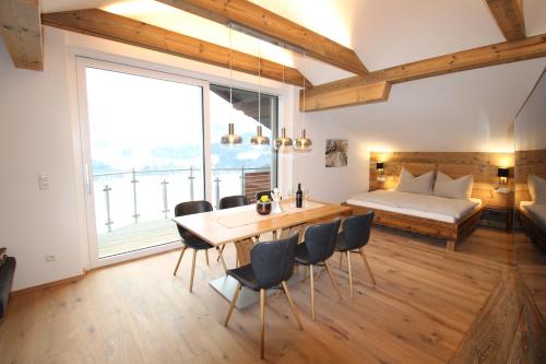 a room with a table and chairs and a bed at Apartmenthaus Vergissmeinnicht in Abtenau