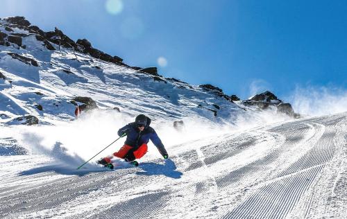 a man is skiing down a snow covered slope at Gschwendtalm Tirol - Luxus-Apartment für Ihre Auszeit in Tulfes