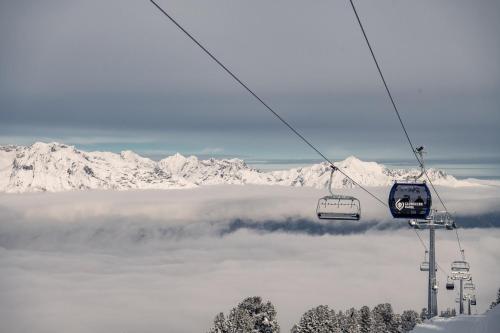 a ski lift flying over a fog covered mountain at Gschwendtalm Tirol - Luxus-Apartment für Ihre Auszeit in Tulfes