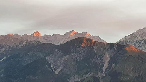 a group of mountains with the sun shining on them at Gschwendtalm Tirol - Luxus-Apartment für Ihre Auszeit in Tulfes