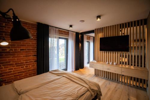 een slaapkamer met een bed en een flatscreen-tv bij Jazzowa Chata in Bielsko-Biala
