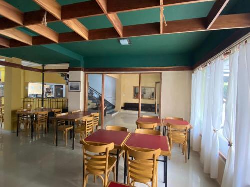 a restaurant with wooden tables and chairs and windows at Hotel Roma in Mar de Ajó