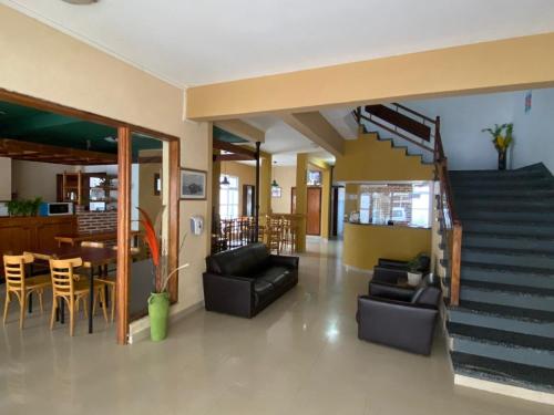 a living room with a staircase and a dining room at Hotel Roma in Mar de Ajó