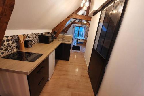 une cuisine avec un comptoir et un couloir dans l'établissement Charmant Studio Hyper Centre, à Lourdes