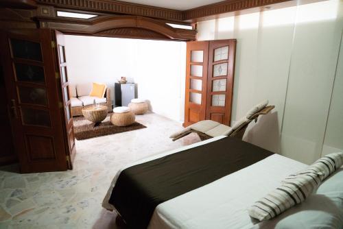 a bedroom with a bed and a living room at Hotel Buena Vista in Bucaramanga