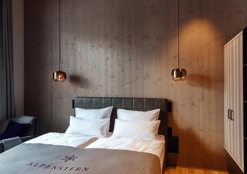 a bedroom with a bed with white sheets and pillows at Alpenstern Genießerhotel in Damuls