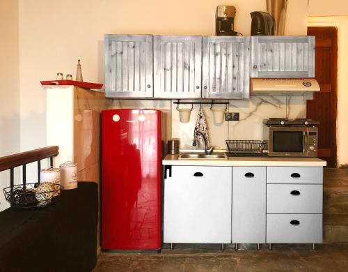 eine Küche mit einem roten Kühlschrank und weißen Schränken in der Unterkunft Seaside Villa in Nea Potidaea