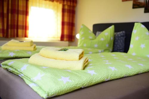 a green bed with towels and pillows on it at Gasthof zur Linde in Pausa