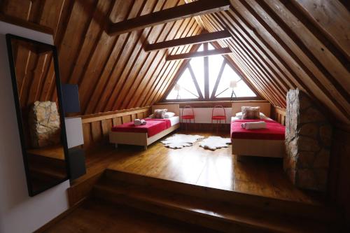 a attic room with two beds and a window at Domek w Górach Chatka Rogasiowa in Rytro