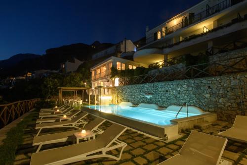 a building with a swimming pool next to a resort at Hotel Il Pino in Praiano