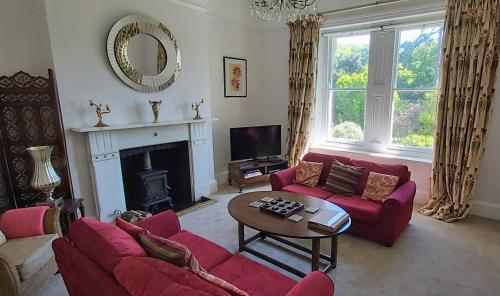 a living room with a red couch and a fireplace at Clarence House Apartments in Ventnor
