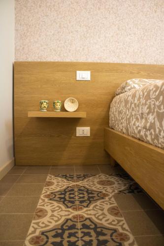 a bedroom with a bed and a shelf and a rug at Salgari Uno in Marina di Ragusa