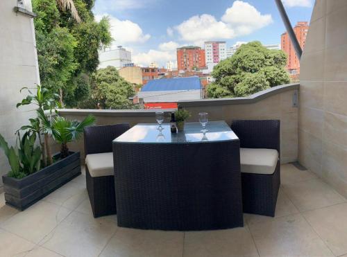 a table and chairs on a balcony with a view of a city at Hotel Buena Vista in Bucaramanga