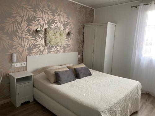 een slaapkamer met een bed met 2 kussens erop bij Hotel Abelia in Montpellier